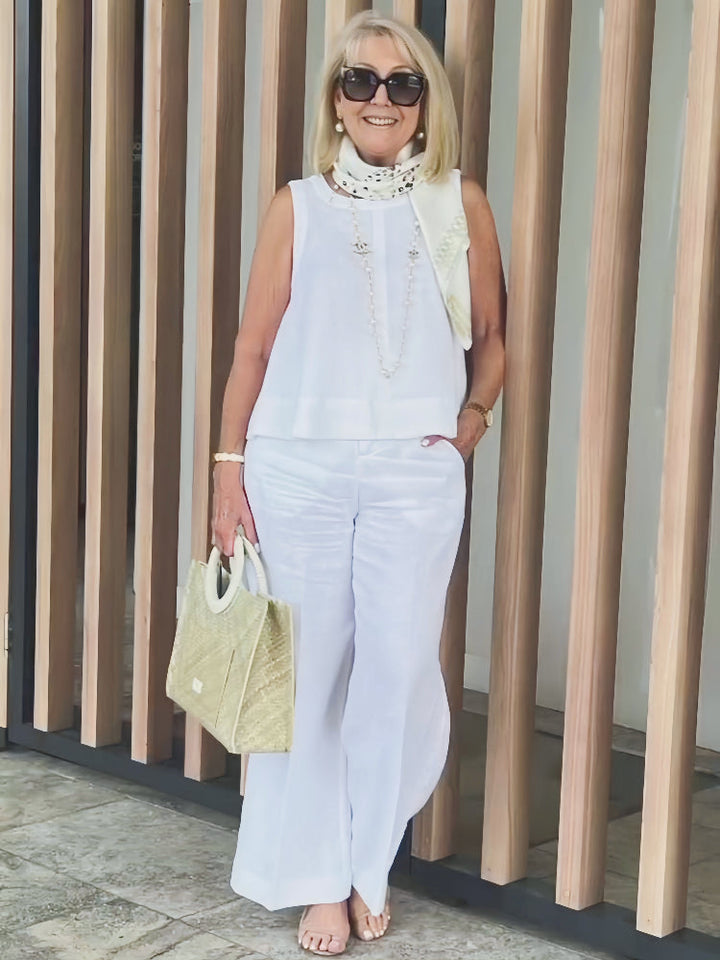 White sleeveless layered two-piece set with beaded high collar and wide-leg pants