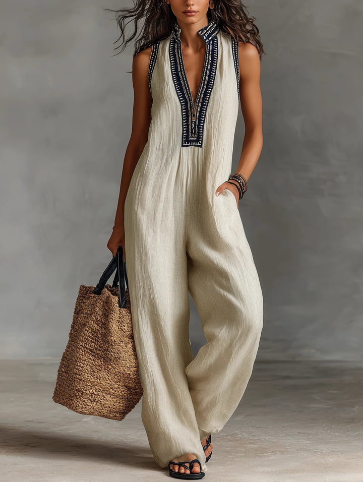 Beige sleeveless jumpsuit with stand collar and navy embroidered placket