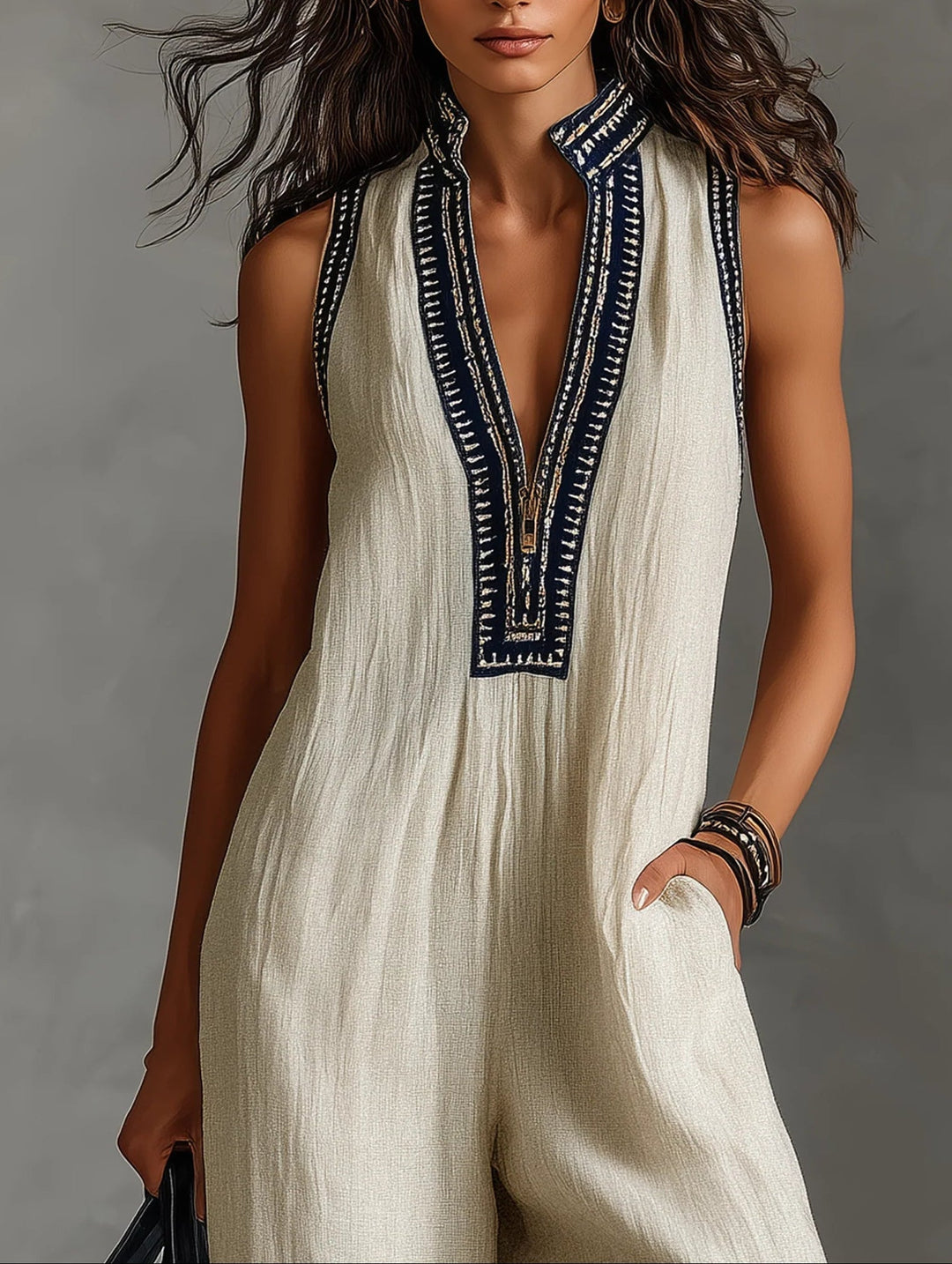 Beige stand-collar sleeveless jumpsuit with navy embroidered V placket