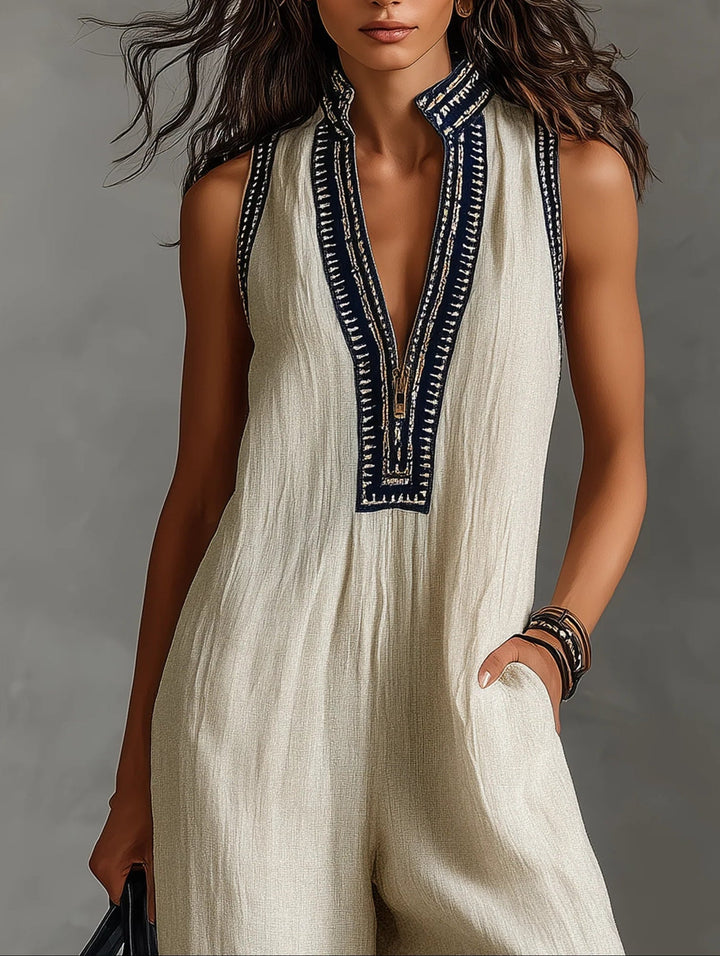 Beige stand-collar sleeveless jumpsuit with navy embroidered V placket