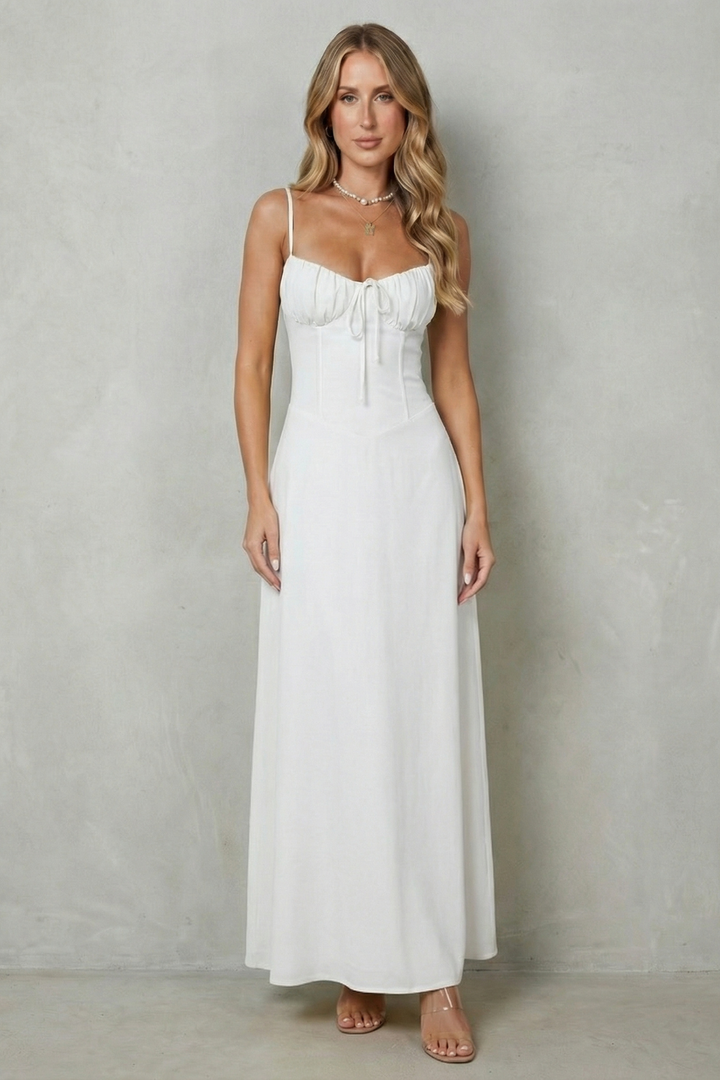 White corset maxi dress with thin straps, gathered bust, and front tie at waist