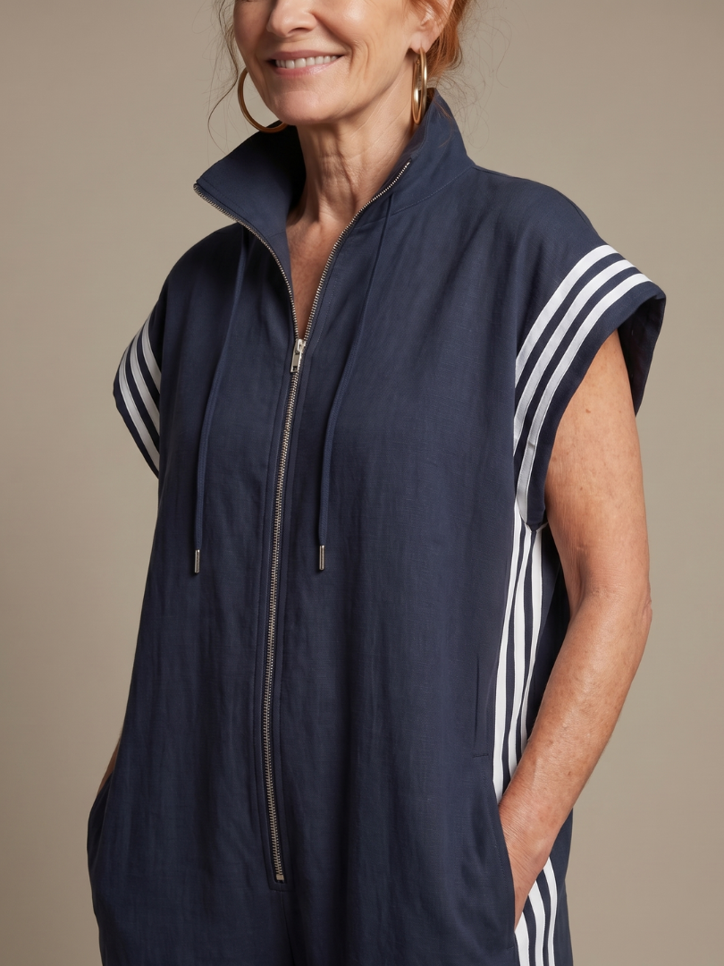 Blue sleeveless zip-front jumpsuit with striped shoulder panels and drawstring hood