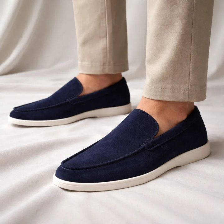 Navy suede slip-on loafer with stitched vamp and white rubber sole