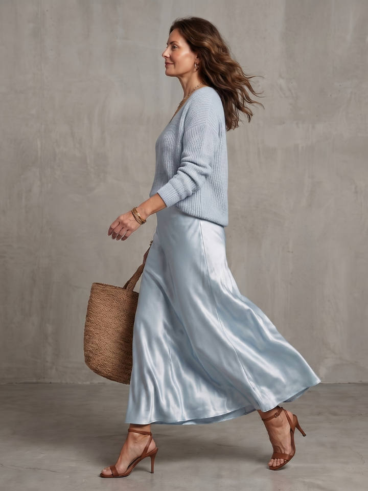 Light blue satin two-piece set with knit V-neck sweater and flowing satin midi skirt