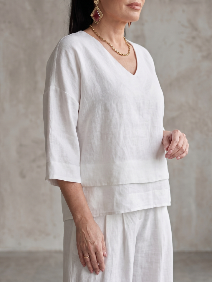 White V-neck top and wide-leg pants set with layered hem detail