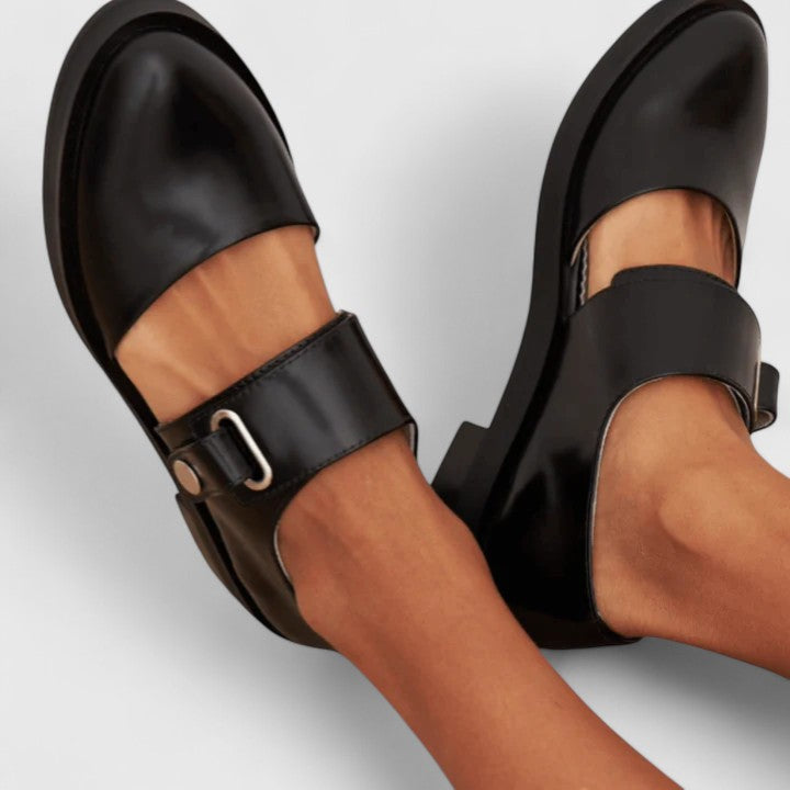 Black buckle strap slide flats, side view of cushioned footbed