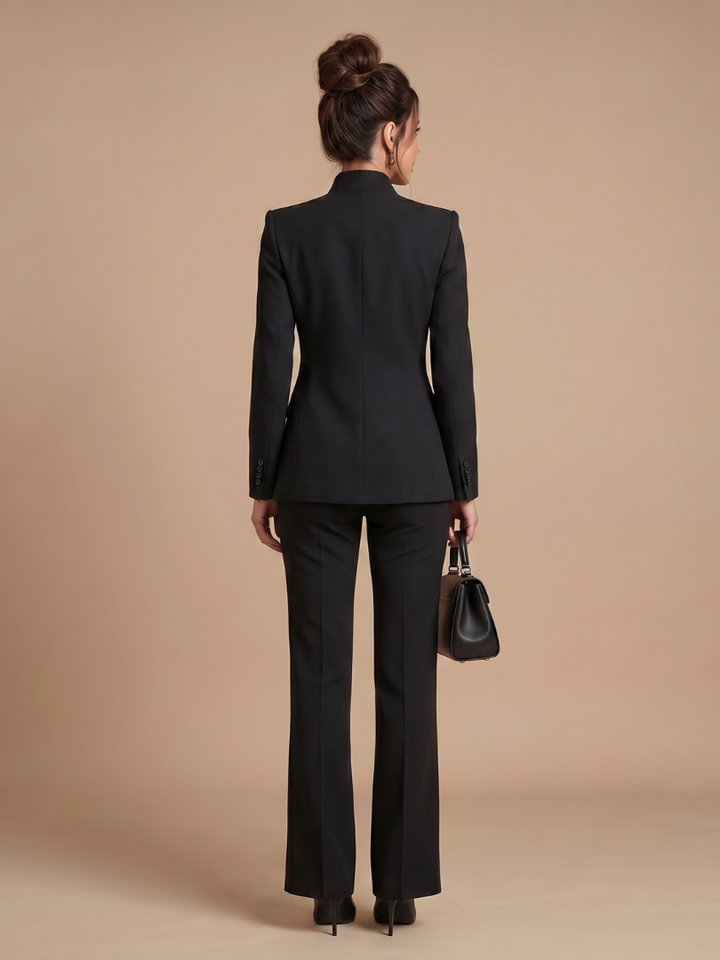 Women’s blazer set in black: back view of fitted blazer and matching trousers.