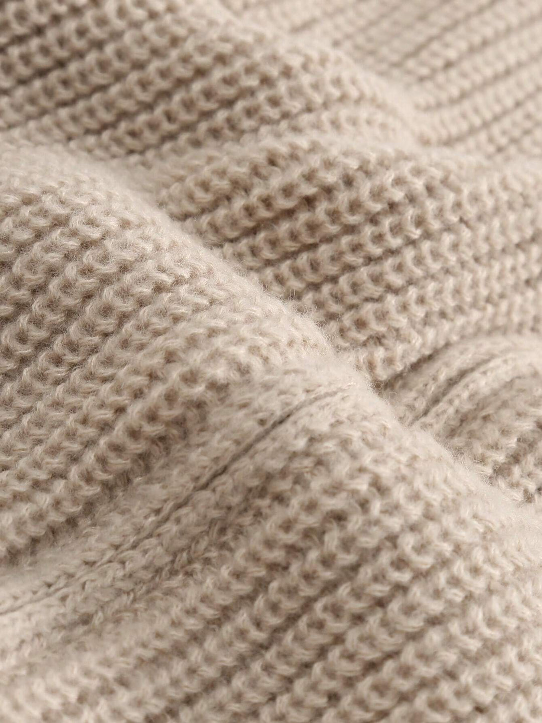 Beige textured knit cardigan fabric close-up with ribbed stitch pattern