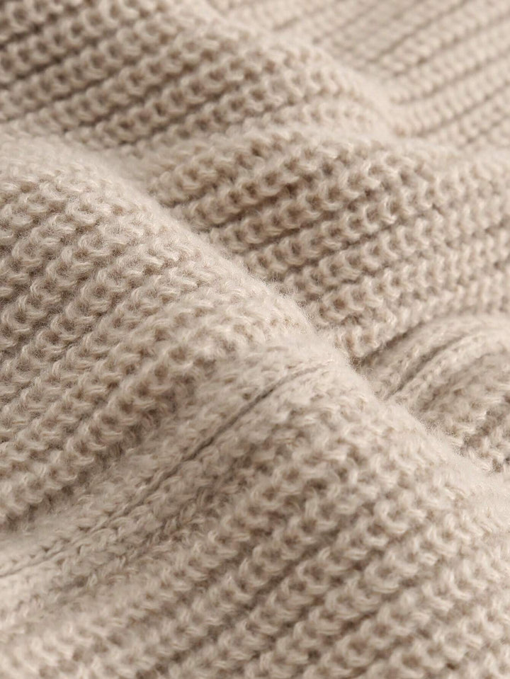 Beige textured knit cardigan fabric close-up with ribbed stitch pattern