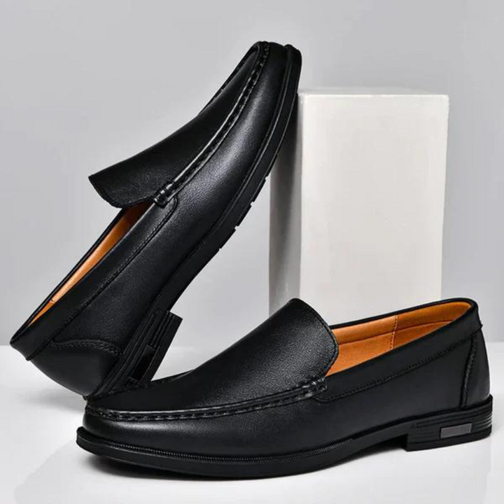 Black leather penny loafers with metal bit and stitched moc-toe, with textured sole