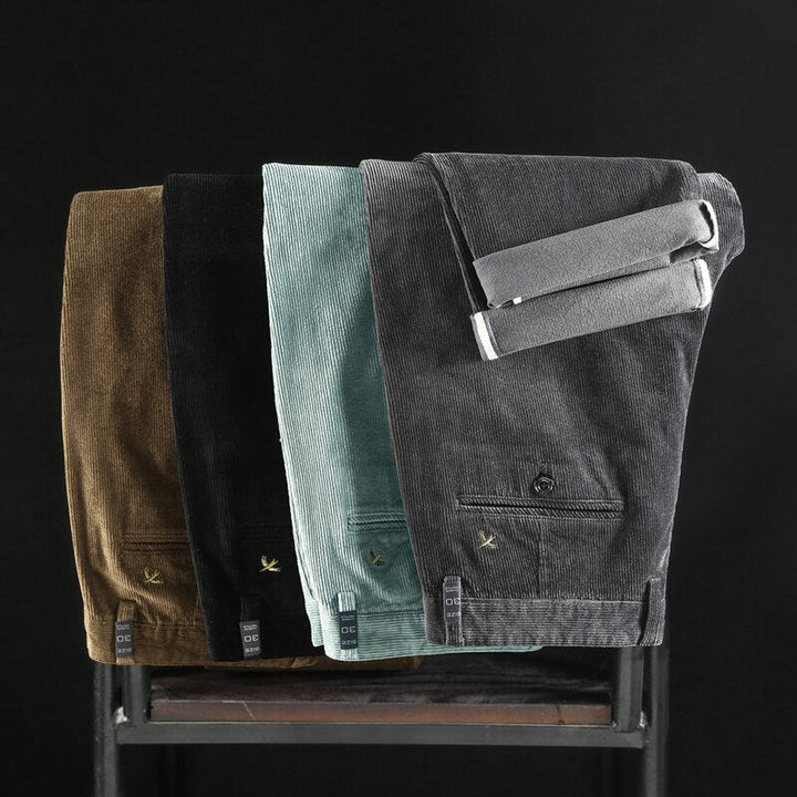 Folded corduroy pants assortment in brown, black, light blue, and gray