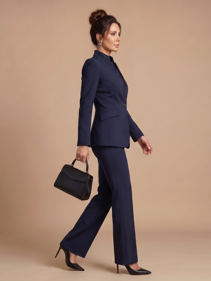 Women’s blazer set in navy blue: side view of blazer and flared trousers with handbag.
