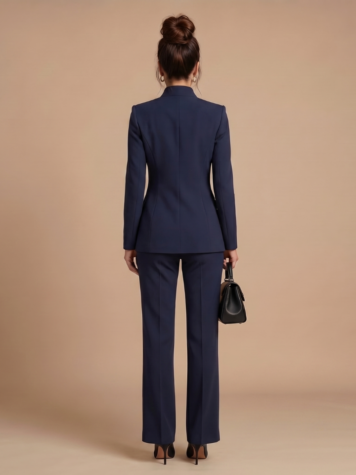 Women’s blazer set in navy blue: back view of blazer and matching long trousers.
