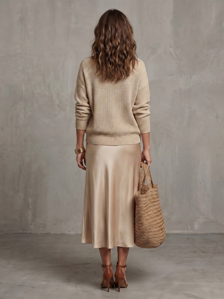 Beige satin two-piece set with knit sweater and satin midi skirt from back