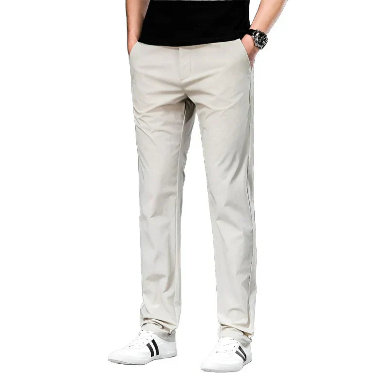 Light beige chino pants with belt loops, slant front pockets, and tapered legs.