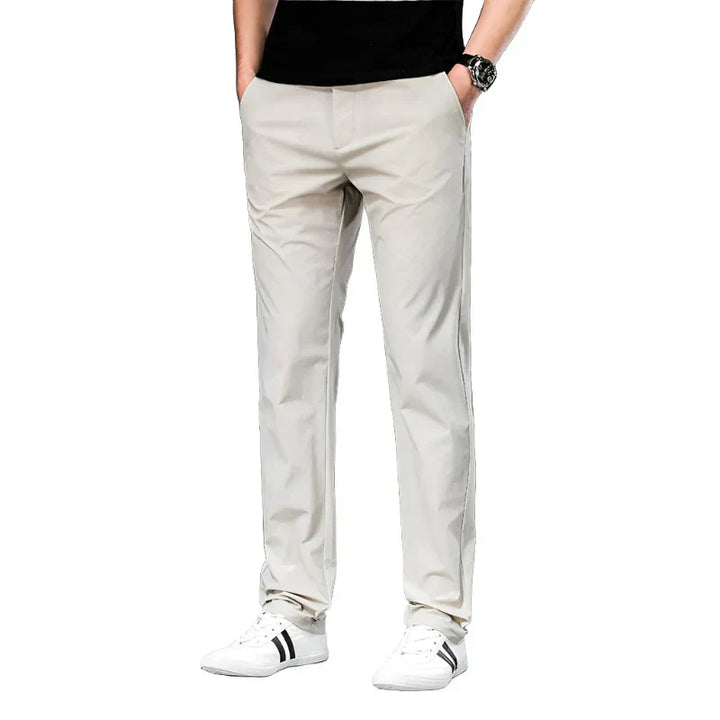 Light beige chino pants with belt loops, slant front pockets, and tapered legs.