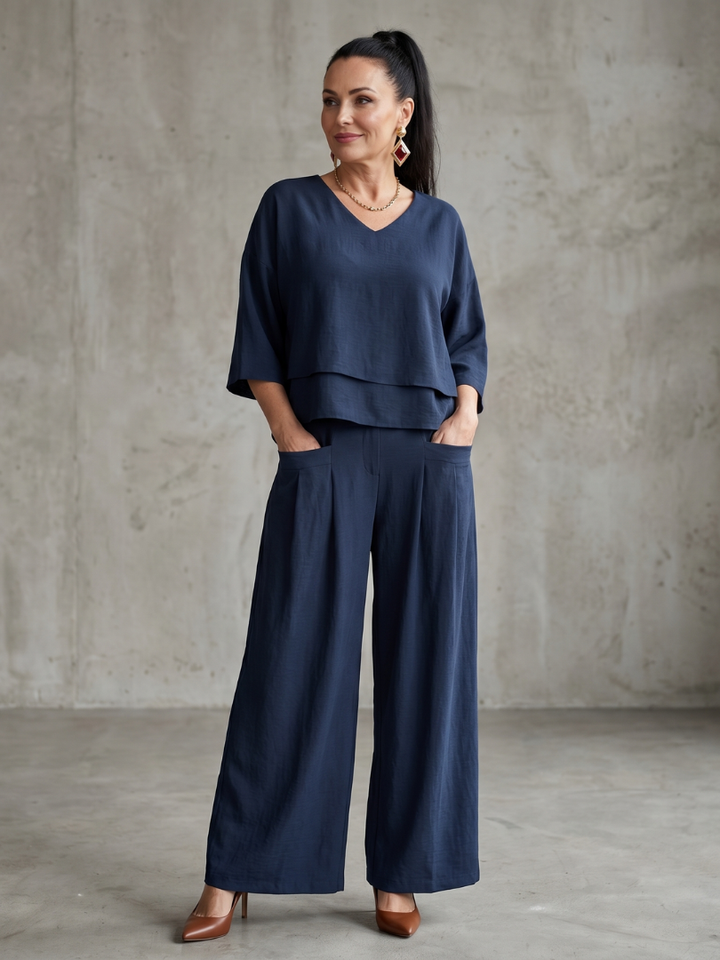 Navy two-piece wide-leg pants set with V-neck tunic top and flowing wide trousers.