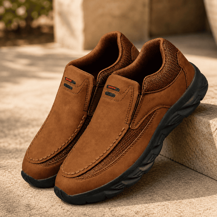 Brown suede slip-on comfort shoes with black treaded sole and side pull tabs