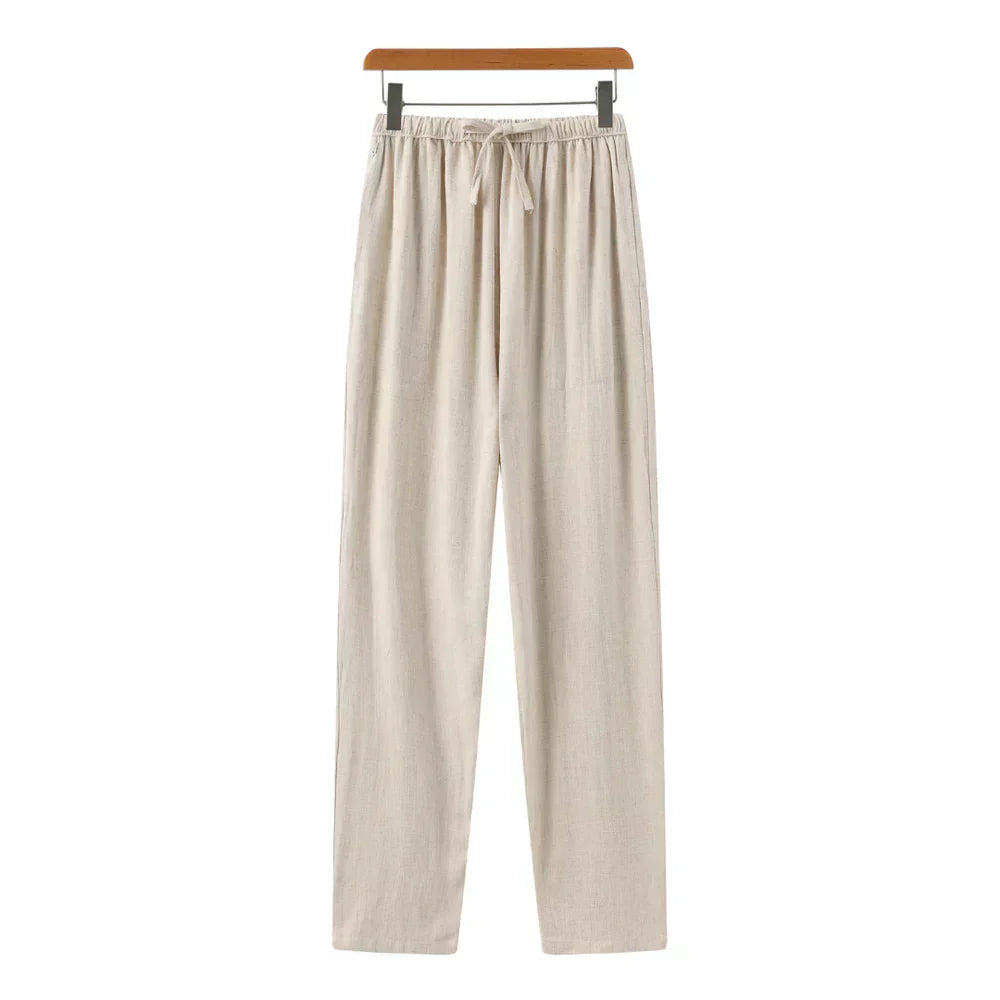 Beige linen pants with elastic waistband, drawstring, and relaxed straight legs.