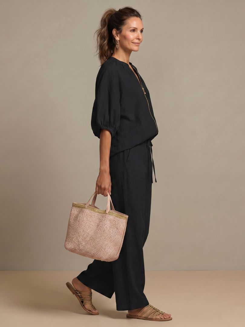 Women’s 2-piece pants set in black, side view of puff sleeve blouse with front zip