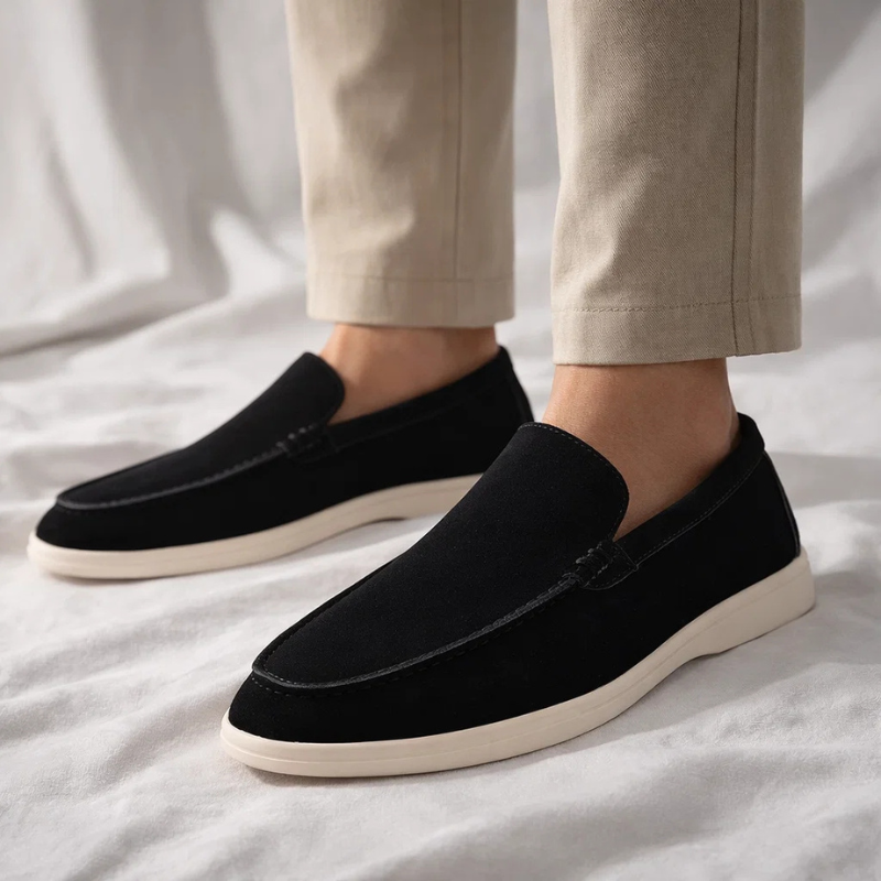 Black suede loafer slip-on worn with pants; stitched moc toe and cream sole