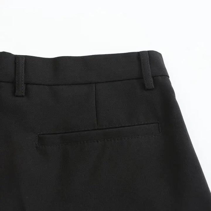 Black stretch pants waistband close-up with belt loops and button detail