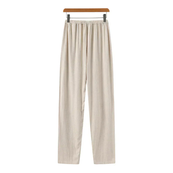Beige linen pants with gathered elastic waist and vertical pleats down the front.