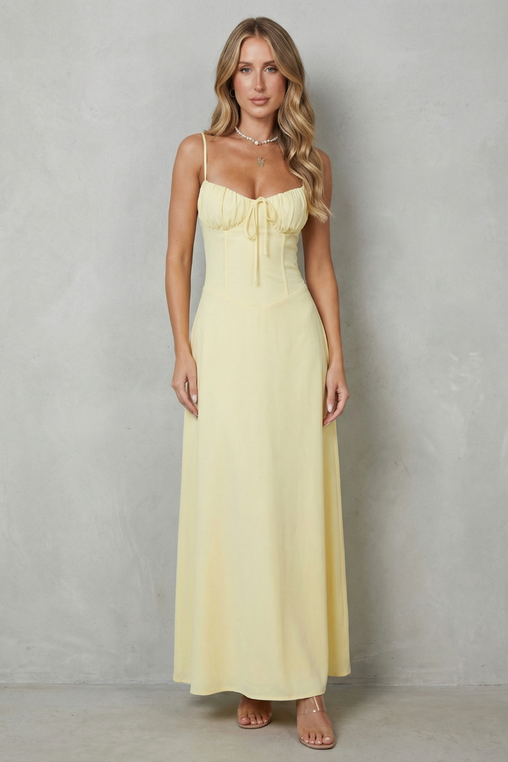 Yellow corset maxi dress with spaghetti straps, ruched bust, and front tie at waist