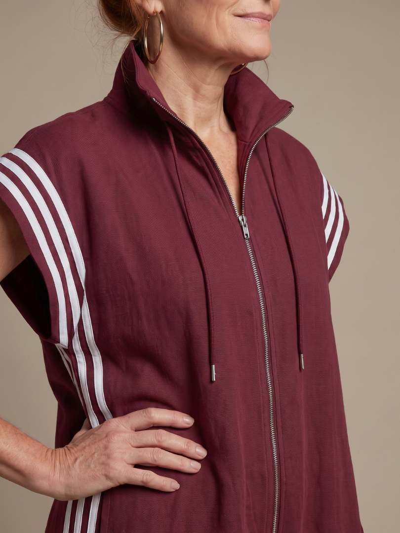 Women’s sleeveless zip-front jumpsuit close-up: maroon with white striped sleeves and zipper