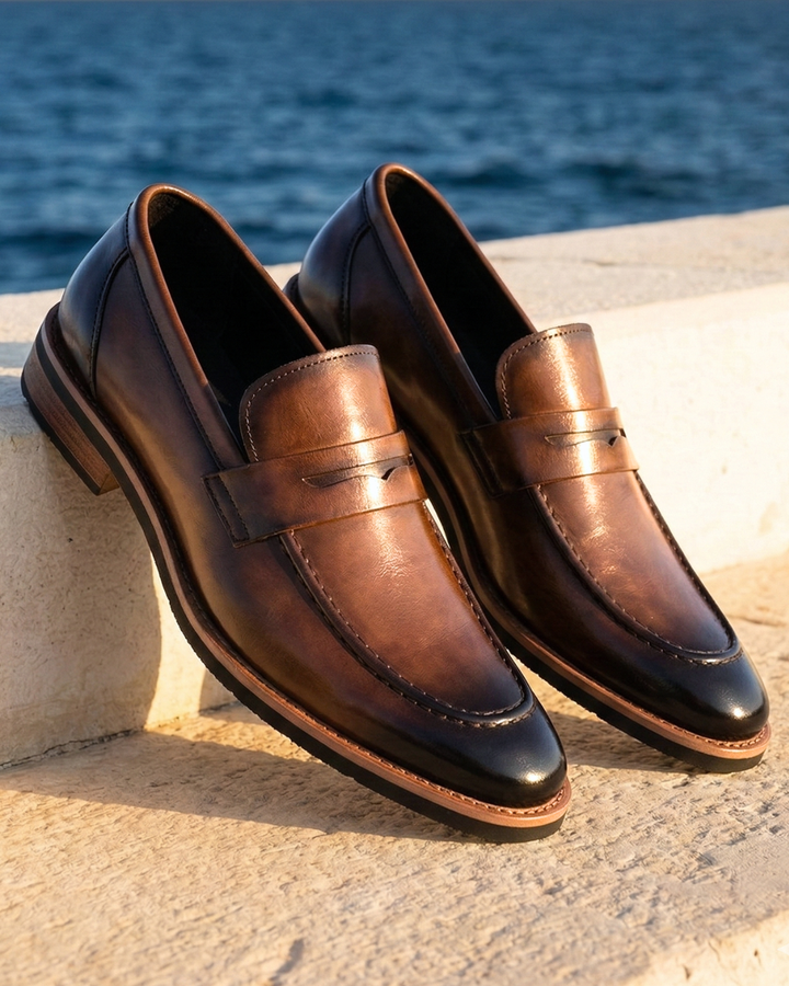 Brown leather loafer with strap detail, stitched apron, and low sole