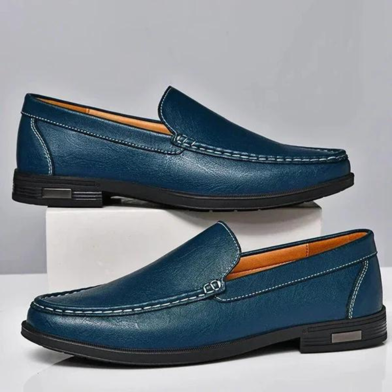 Blue leather loafers set with metal bit, contrast stitching, and treaded black sole