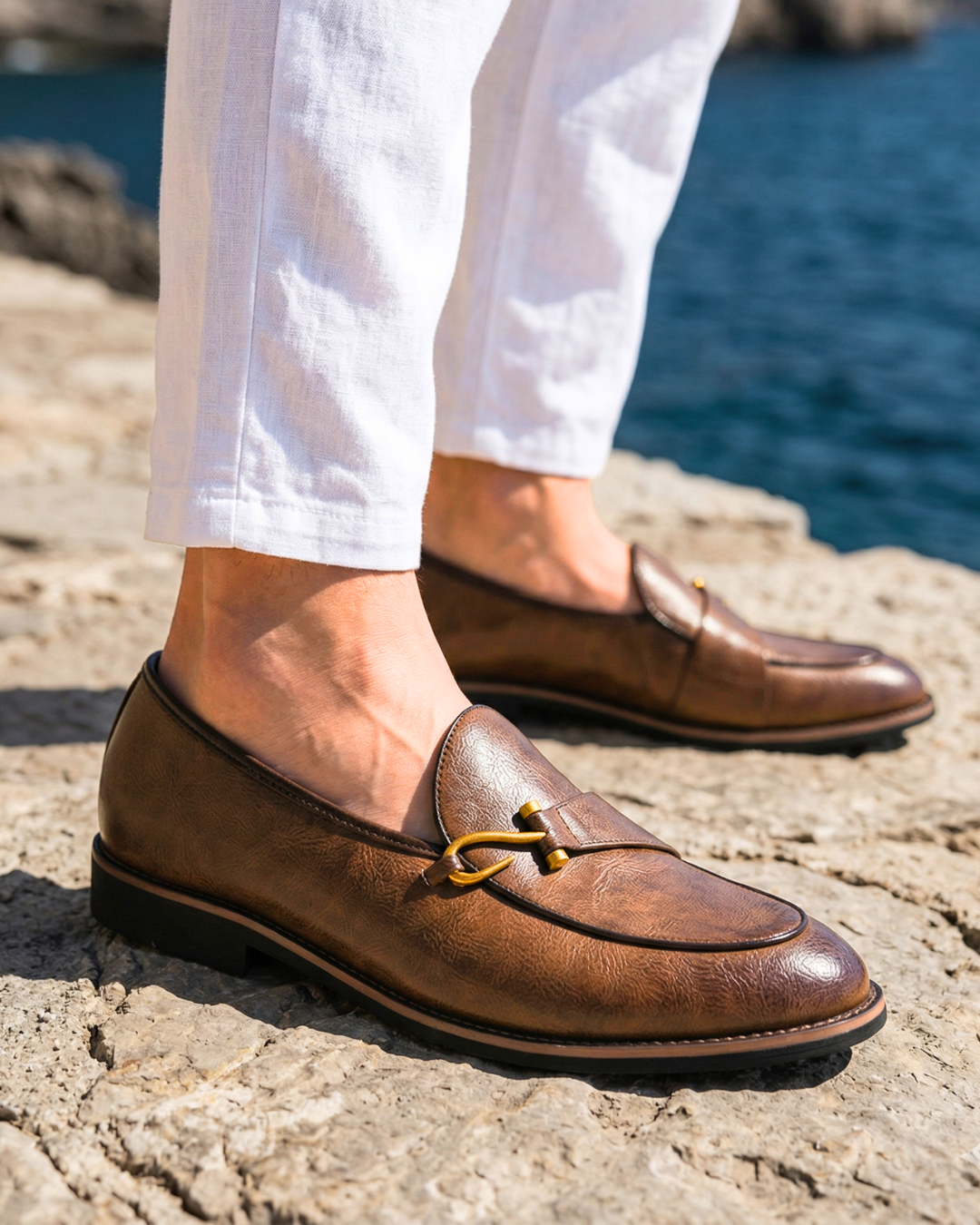Brown leather nautical loafer on foot with gold-toned bit detail