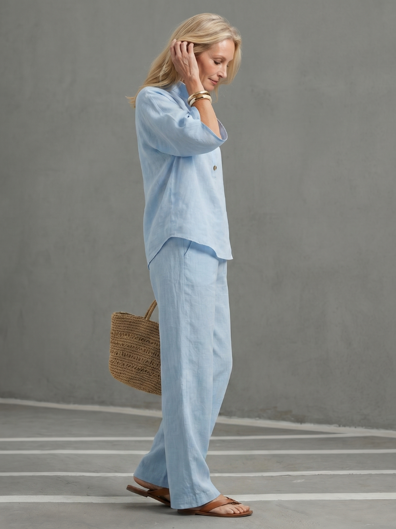 Sky blue button blouse and matching wide-leg pants set with side profile, three-quarter sleeves.