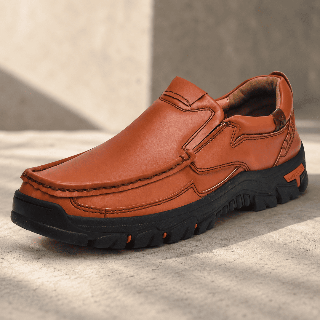 Rust-brown slip-on loafer-style shoes with stitched paneling, thick tread sole, logo patch
