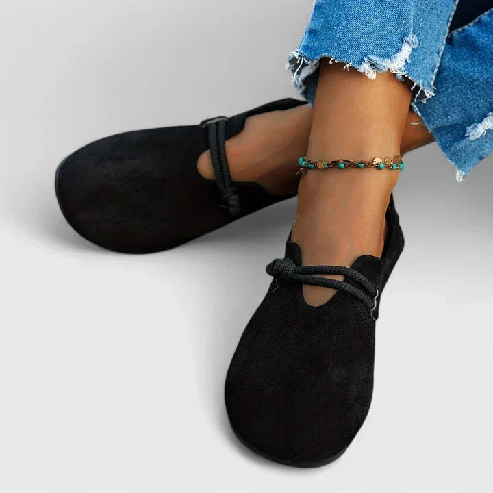 Black slip-on flats with rope band detail at the instep and rounded toe