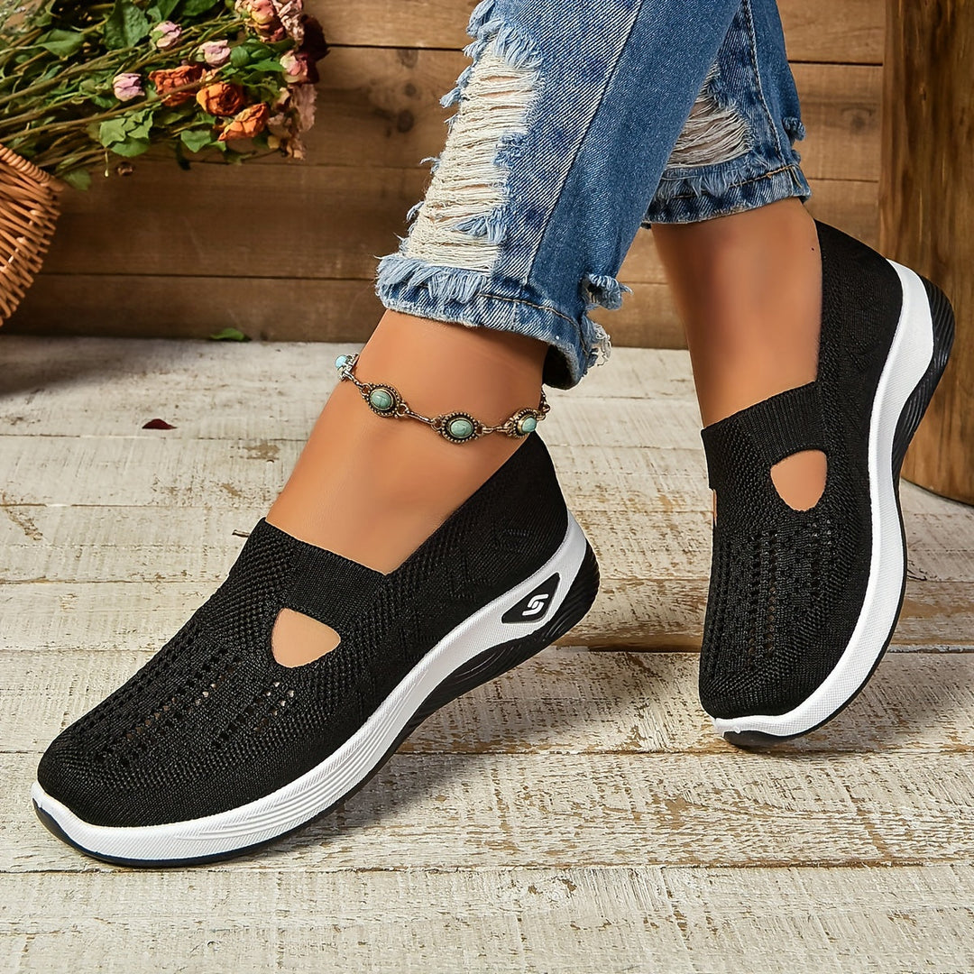Black knit slip-on sneakers with white sole and side cutout panels