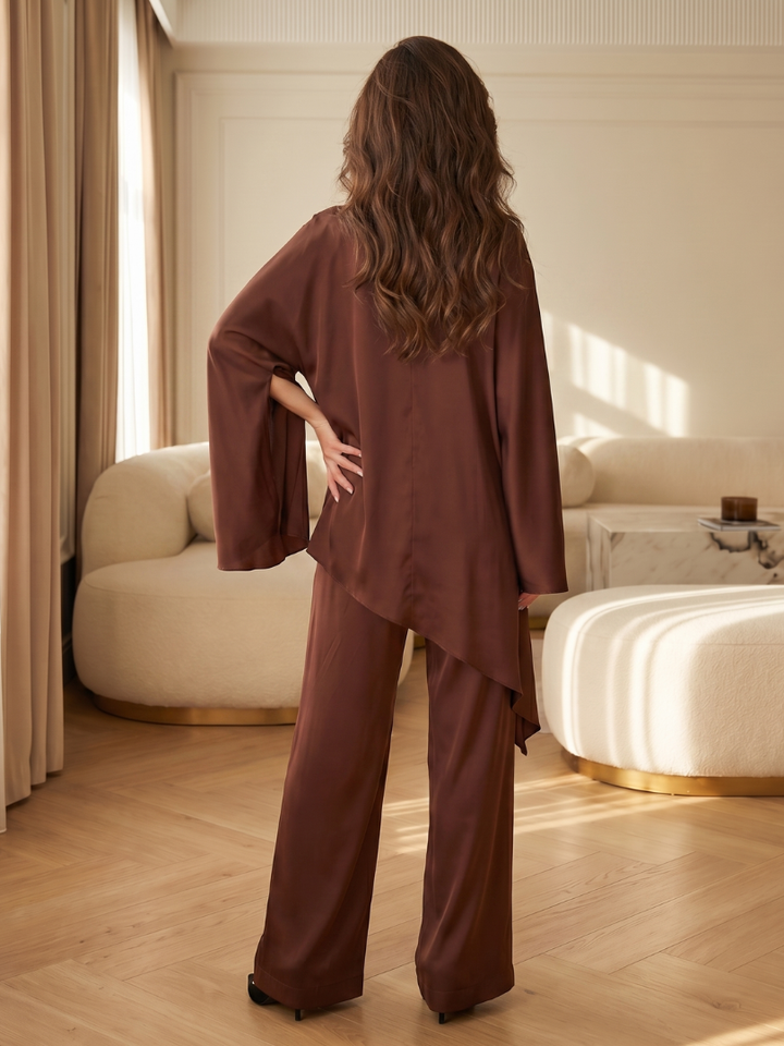 Brown asymmetrical two-piece set, back drape over wide-leg pants