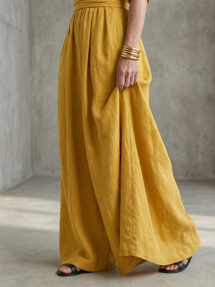 Yellow wrap jumpsuit with tie waist detail and flowing wide-leg pant legs
