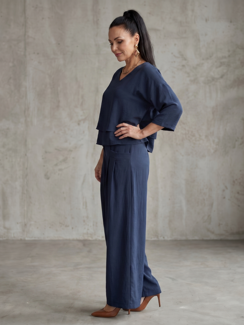 Navy wide-leg pants set with layered V-neck tunic top and high-waist wide trousers, side view.