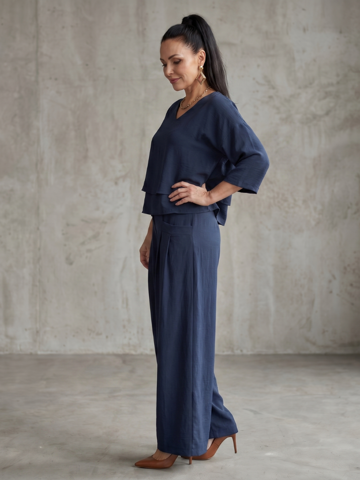 Navy wide-leg pants set with layered V-neck tunic top and high-waist wide trousers, side view.