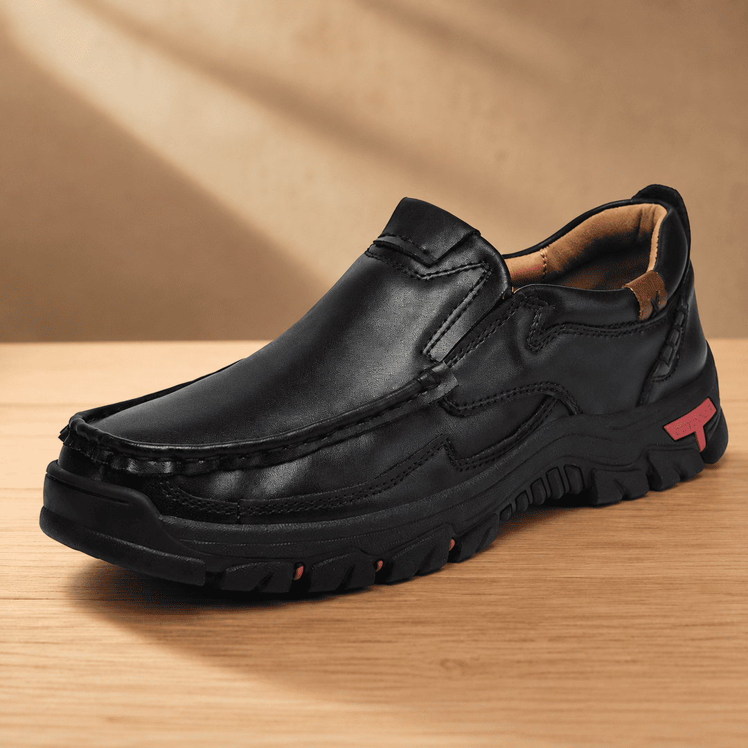 Black slip-on loafer-style shoes with cushioned sole and contrast logo patch