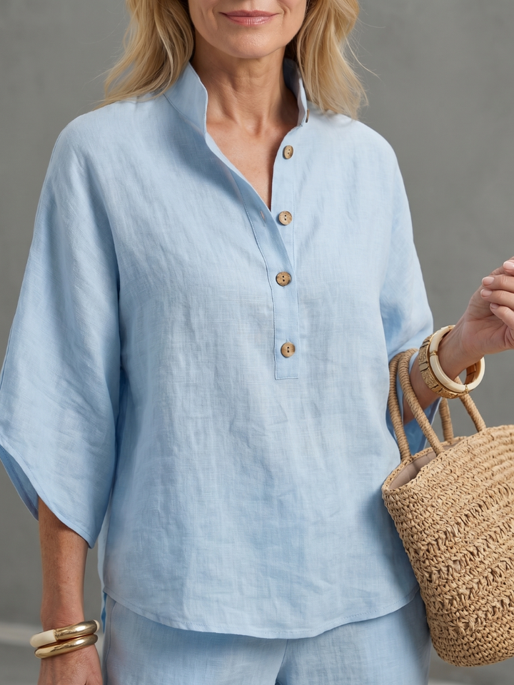 Sky blue button-up blouse top with gold buttons and wide collar, paired with matching pants.