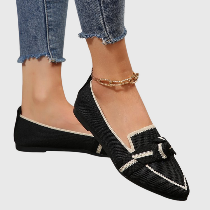 Black knit loafer shoes with white stripe trim and bow detail.