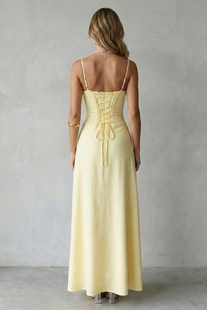 Back view of yellow corset maxi dress with crisscross lacing and open back straps
