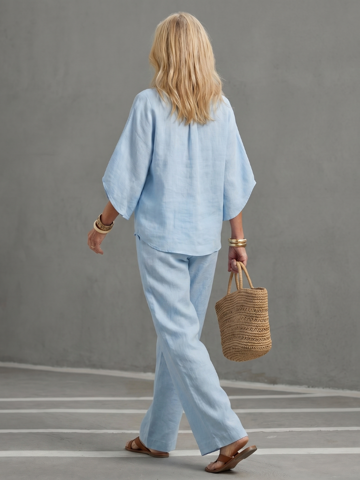 Sky blue button blouse and wide-leg pants set seen from the back, three-quarter sleeves.