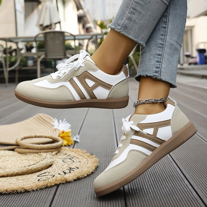 Low top lace-up sneakers in white and tan with cutout side details and gum sole