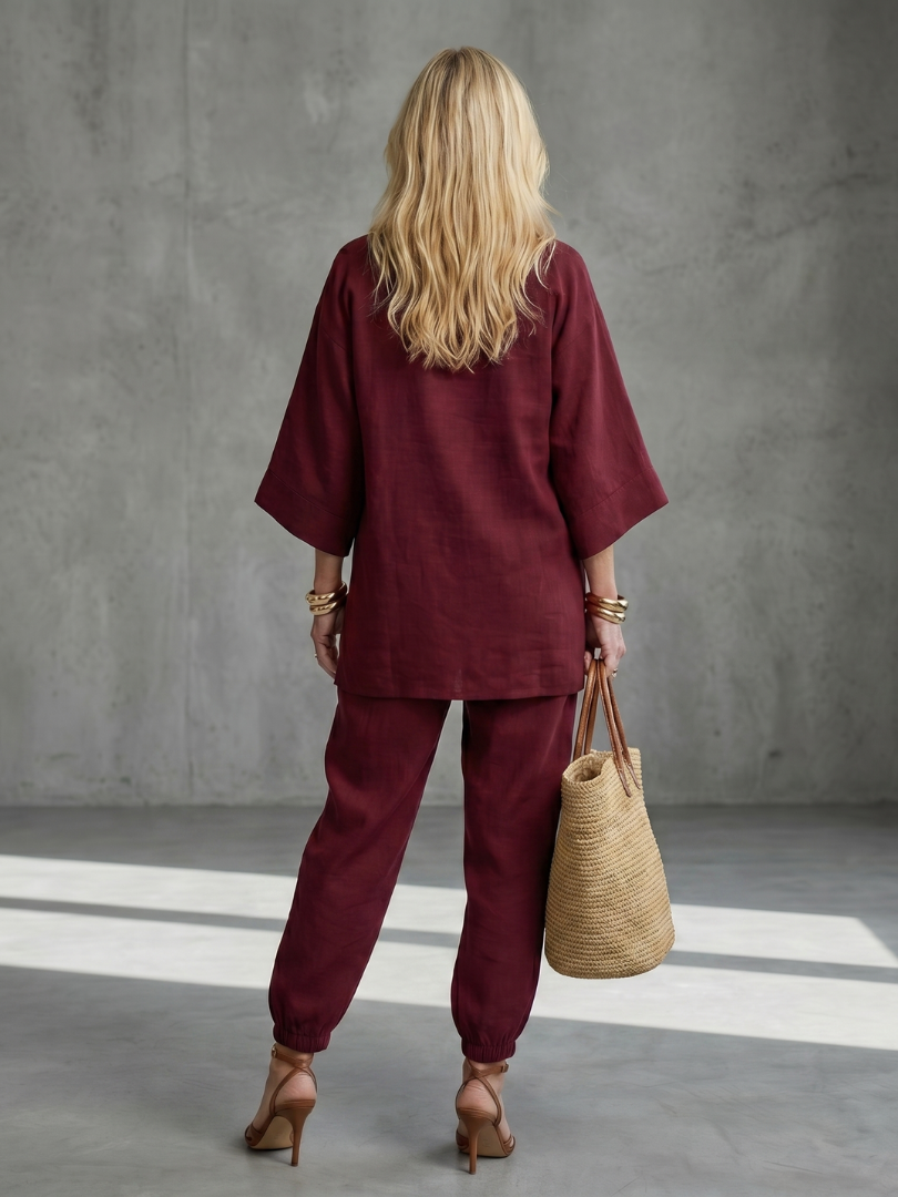 Burgundy women’s V-neck two-piece set with tunic top and relaxed ankle pants, back view