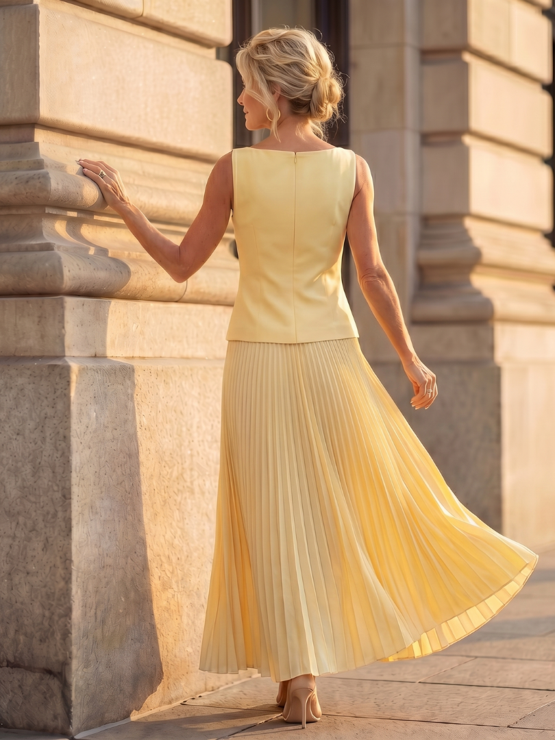 Yellow pleated two-piece set with sleeveless top and pleated midi skirt, back view