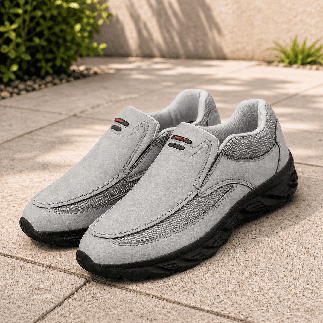 Grey suede slip-on shoes with rounded toe, black treaded sole and side pull tabs