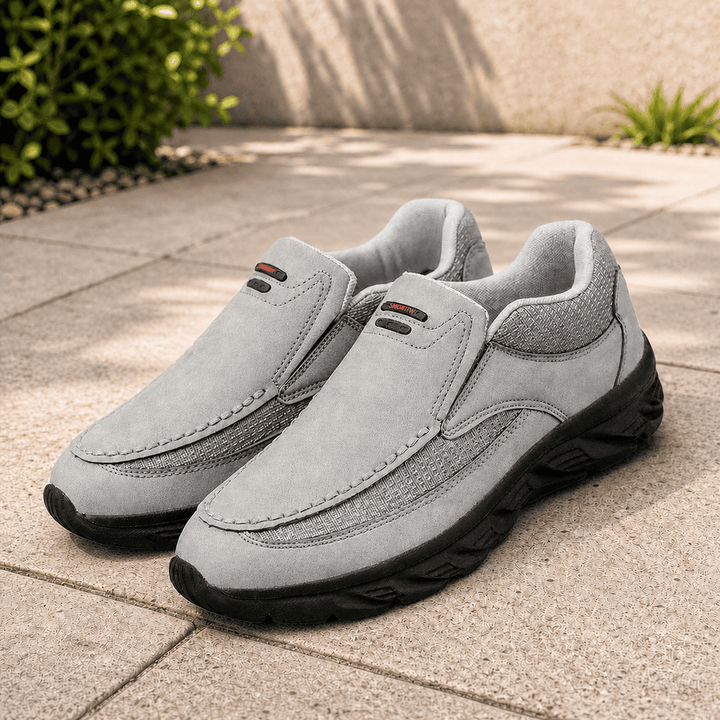 Grey suede slip-on shoes with rounded toe, black treaded sole and side pull tabs